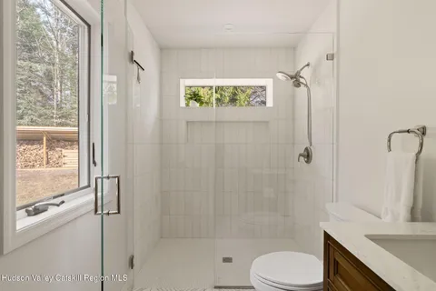 a bathroom with a granite countertop bathtub shower sink vanity and toilet