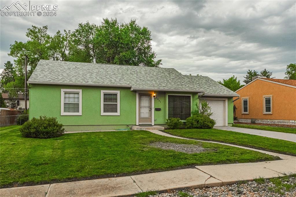 1407 Alexander Road Colorado Springs, CO 80909 - Photo 1 of 27 a view of a yard in front of a house