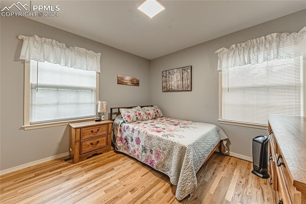 1407 Alexander Road Colorado Springs, CO 80909 - Photo 11 of 27 a bedroom with a bed dresser and a window