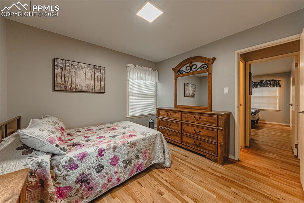1407 Alexander Road Colorado Springs, CO 80909 - Photo 12 of 27 a bedroom with a bed and a lamp on dresser