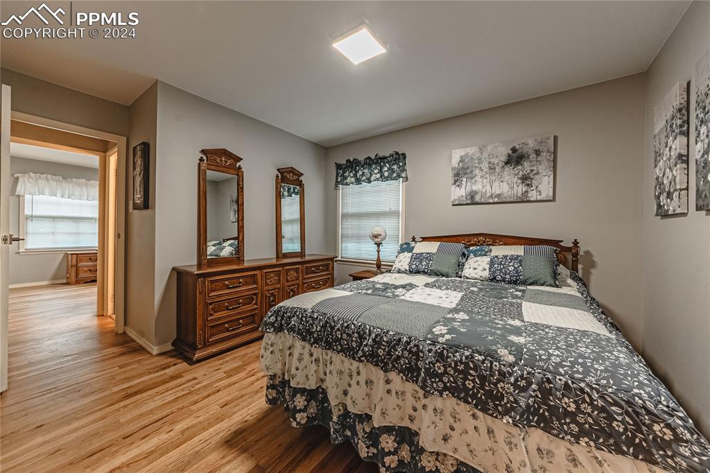 1407 Alexander Road Colorado Springs, CO 80909 - Photo 14 of 27 a bedroom with a bed and wooden floor