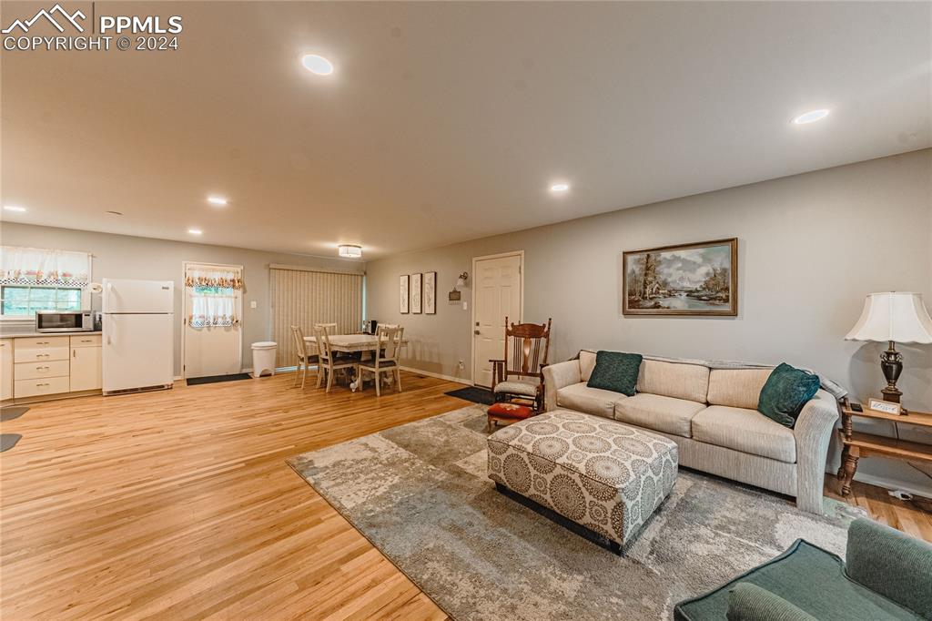 1407 Alexander Road Colorado Springs, CO 80909 - Photo 2 of 27 a living room with furniture and wooden floor