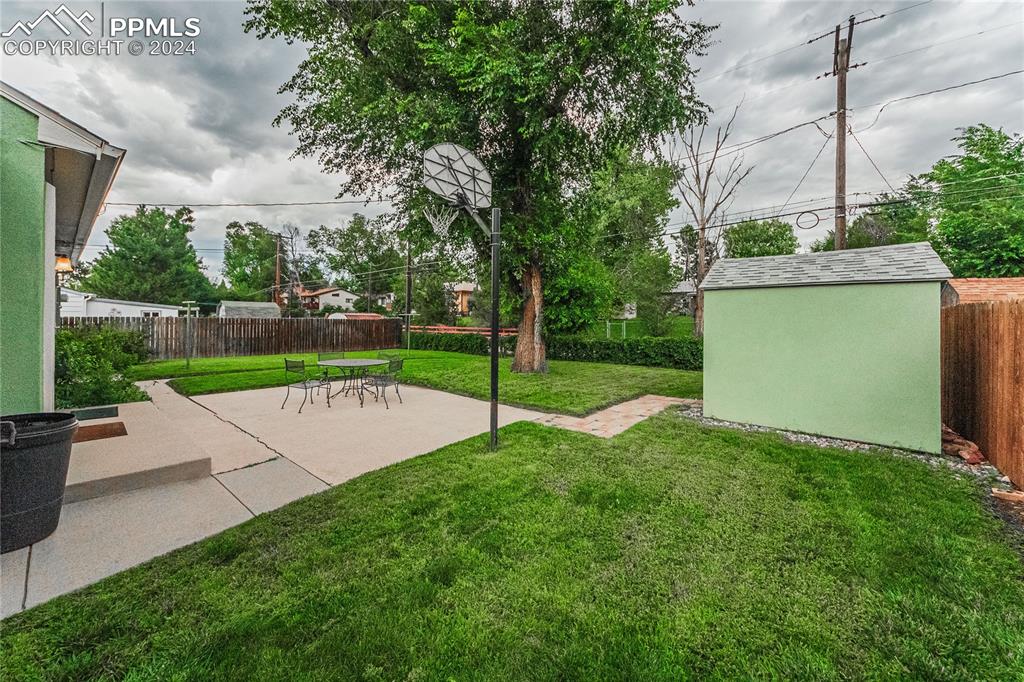 1407 Alexander Road Colorado Springs, CO 80909 - Photo 21 of 27 a view of a backyard with a small cabin