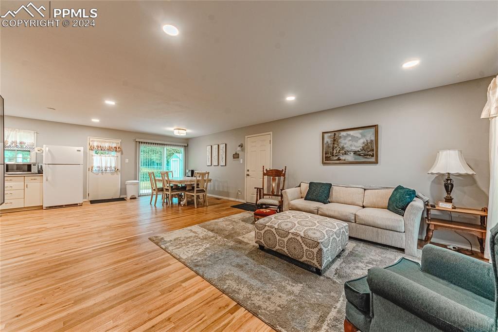 1407 Alexander Road Colorado Springs, CO 80909 - Photo 4 of 27 a living room with furniture and wooden floor