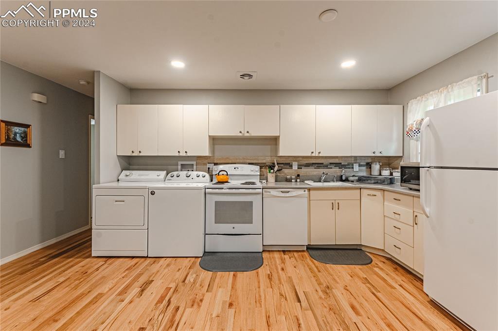 1407 Alexander Road Colorado Springs, CO 80909 - Photo 7 of 27 a kitchen with granite countertop white cabinets and white appliances