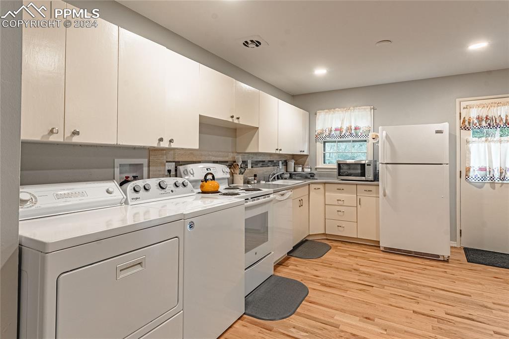 1407 Alexander Road Colorado Springs, CO 80909 - Photo 10 of 27 a kitchen with granite countertop white cabinets and white appliances