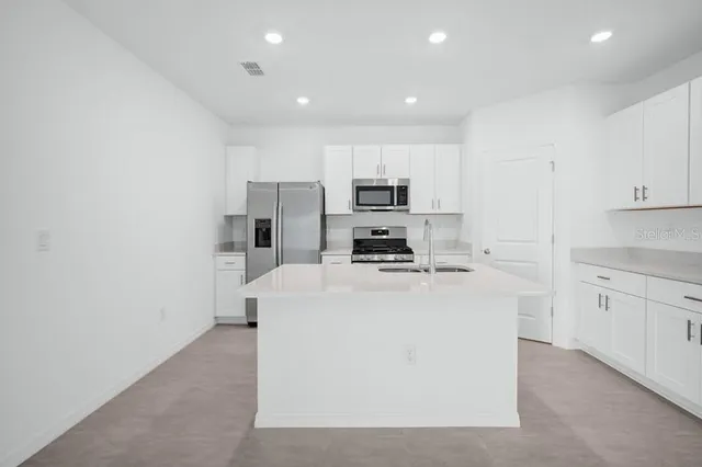 a living room with furniture and kitchen view