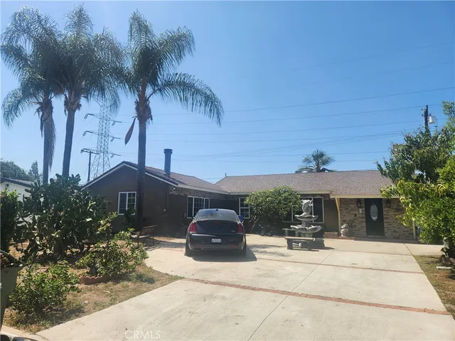 a front view of a house with a yard and palm trees