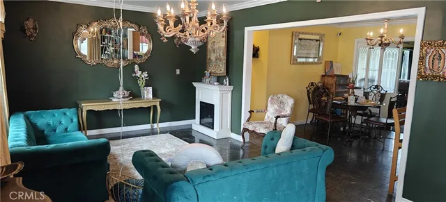 a living room with furniture a chandelier and a fireplace