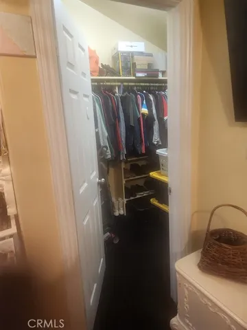 a view of walk in closet with clothes