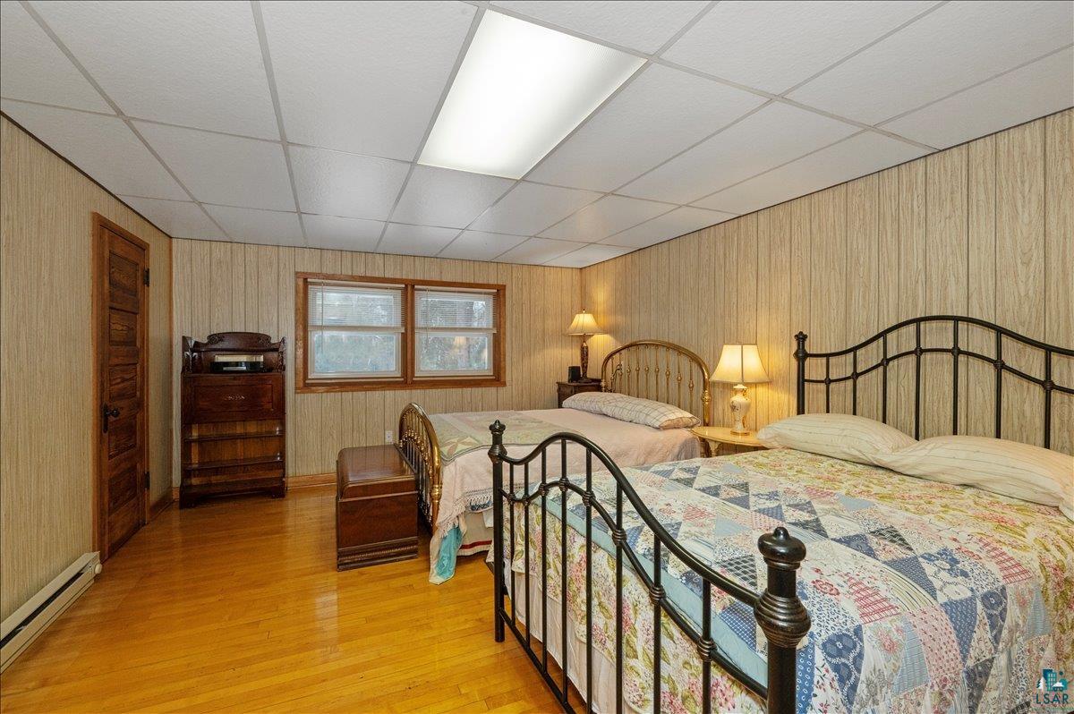 7596 Werner Road Virginia, MN 55792 - Photo 16 of 27 Room featuring wood-finish flooring, paneled wall finishes, and a drop ceiling with a recessed light fixture