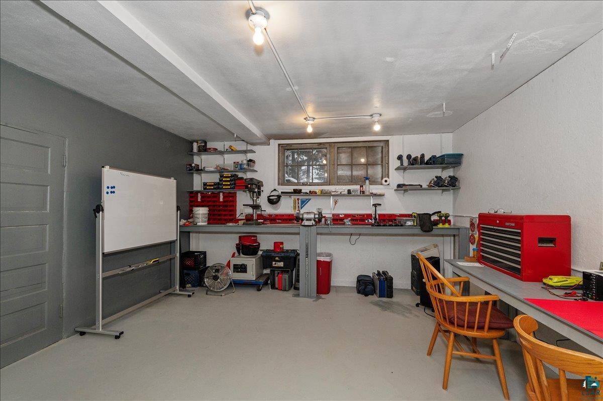 7596 Werner Road Virginia, MN 55792 - Photo 19 of 27 Versatile utility space featuring built-in shelving, a workbench, and a window for natural light