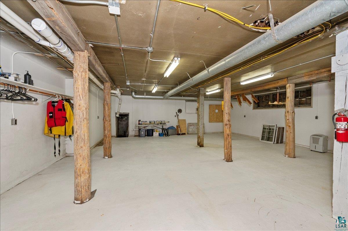 7596 Werner Road Virginia, MN 55792 - Photo 21 of 27 Spacious utility area featuring exposed wooden support beams and a painted concrete floor