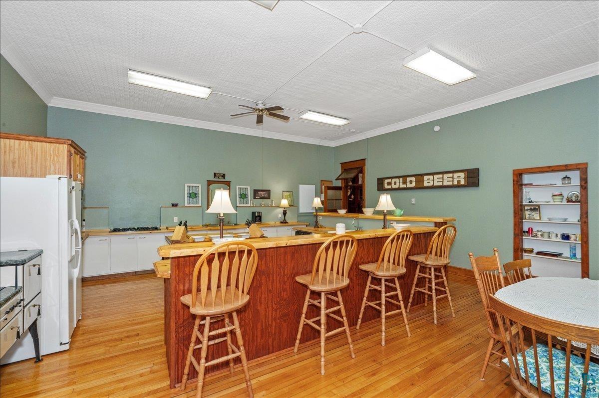 7596 Werner Road Virginia, MN 55792 - Photo 8 of 27 Spacious common area featuring a substantial wood-finish bar, recessed lighting, and light wood-finish flooring