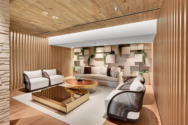 a view of a hallway with wooden floor and a living room