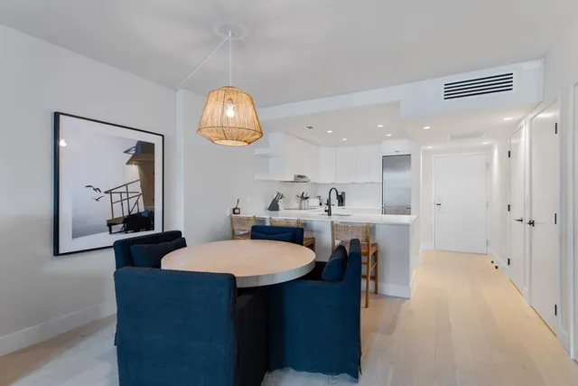a view of a dining room with furniture and a chandelier fan