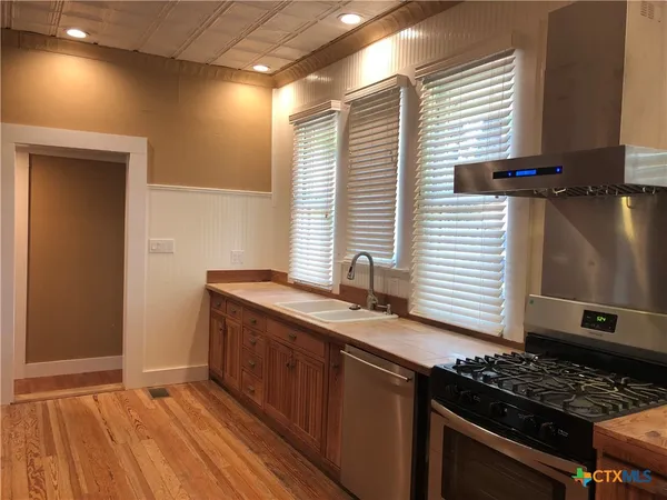 a kitchen with stainless steel appliances granite countertop a sink stove and cabinets