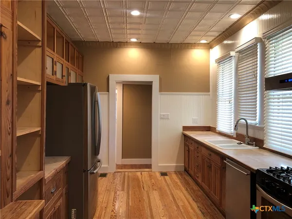 a kitchen with granite countertop a sink a counter space and cabinets
