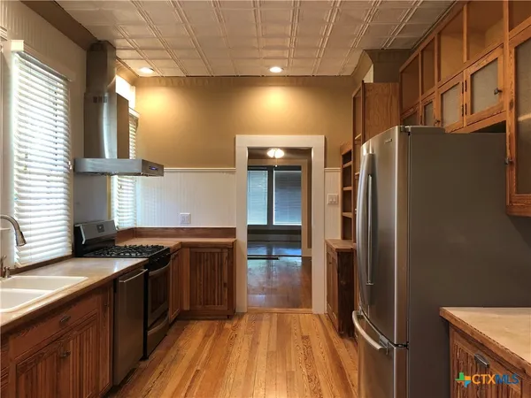 a kitchen with stainless steel appliances granite countertop a stove a sink and a refrigerator