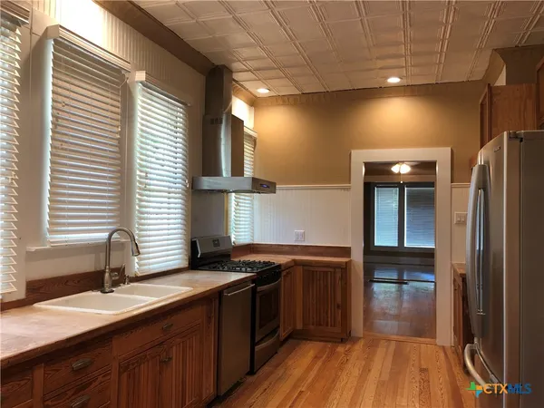a kitchen with a sink a counter top space stainless steel appliances and a window