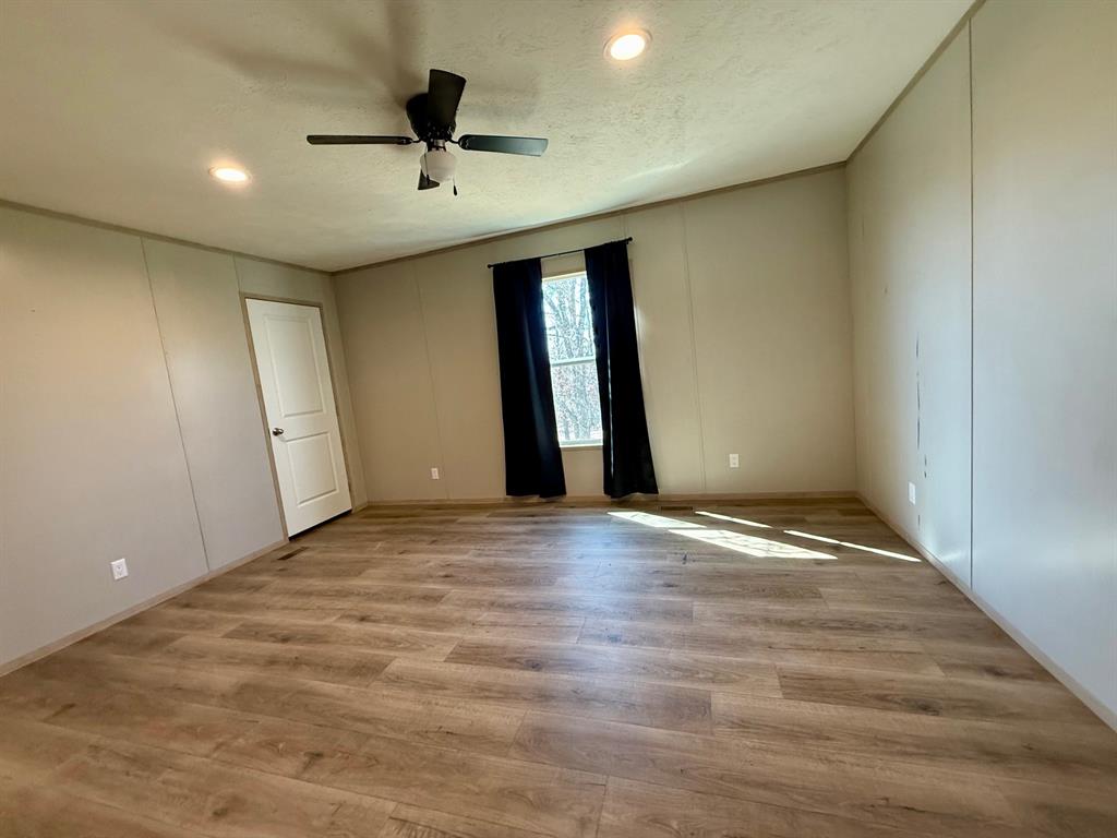 136 County Road 1736 Chico, TX 76431 - Photo 21 of 27 an empty room with wooden floor and windows