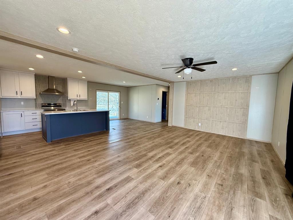 136 County Road 1736 Chico, TX 76431 - Photo 4 of 27 a view of kitchen and empty room with wooden floor
