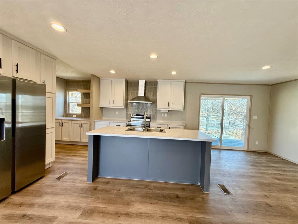 136 County Road 1736 Chico, TX 76431 - Photo 6 of 27 a large kitchen with stainless steel appliances a large counter top a stove a refrigerator and a sink