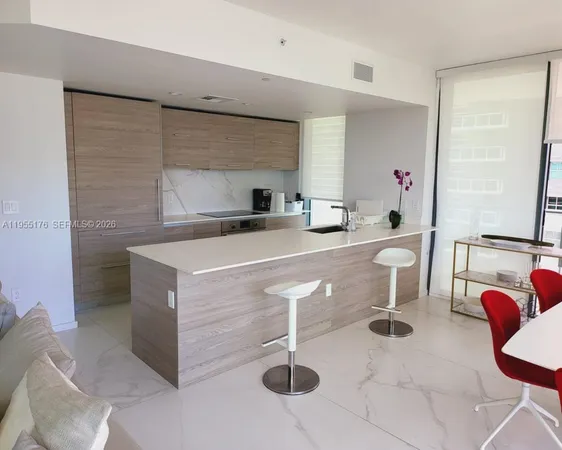 a kitchen with stainless steel appliances a sink a table and chairs