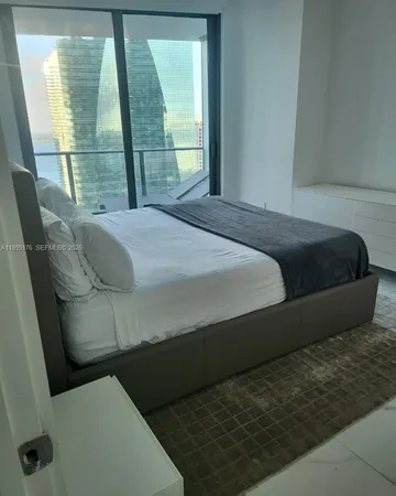a bedroom with a bed and glass door
