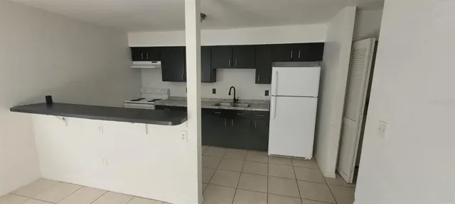 a kitchen with a refrigerator and a sink