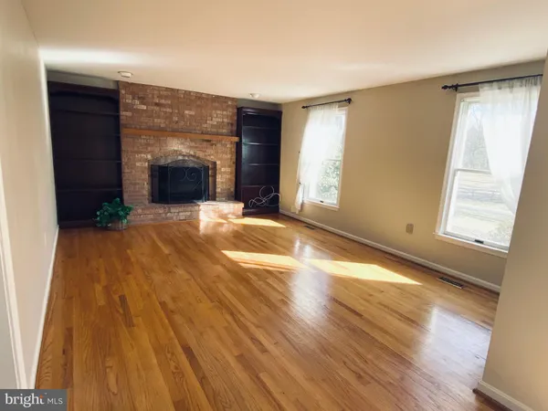 a view of empty room with wooden floor and fireplace