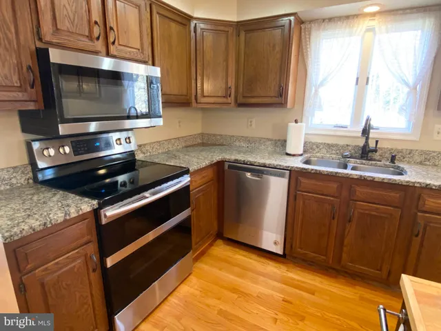 a kitchen with stainless steel appliances granite countertop a sink stove and microwave
