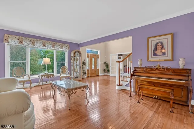 a living room with furniture a wooden floor and a large window