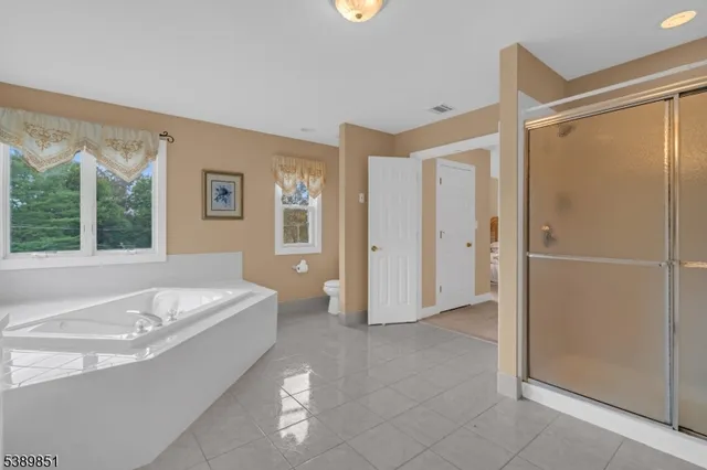 a spacious bathroom with a tub shower and sink