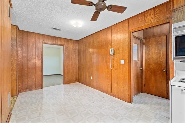 an empty room with a chandelier fan