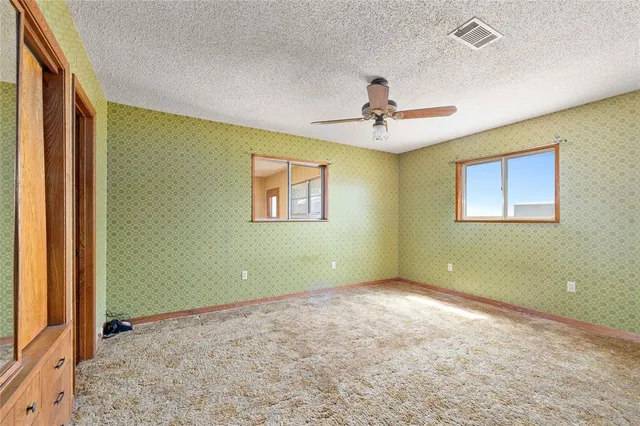 a view of a big room with wooden floor and windows in a room