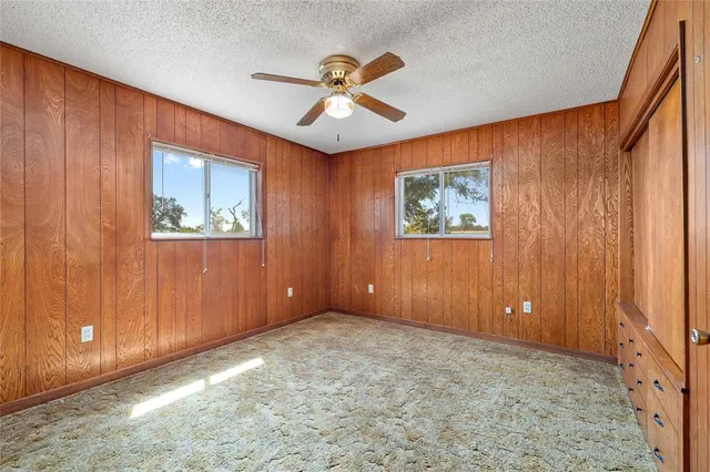 an empty room with closet and chandelier fan