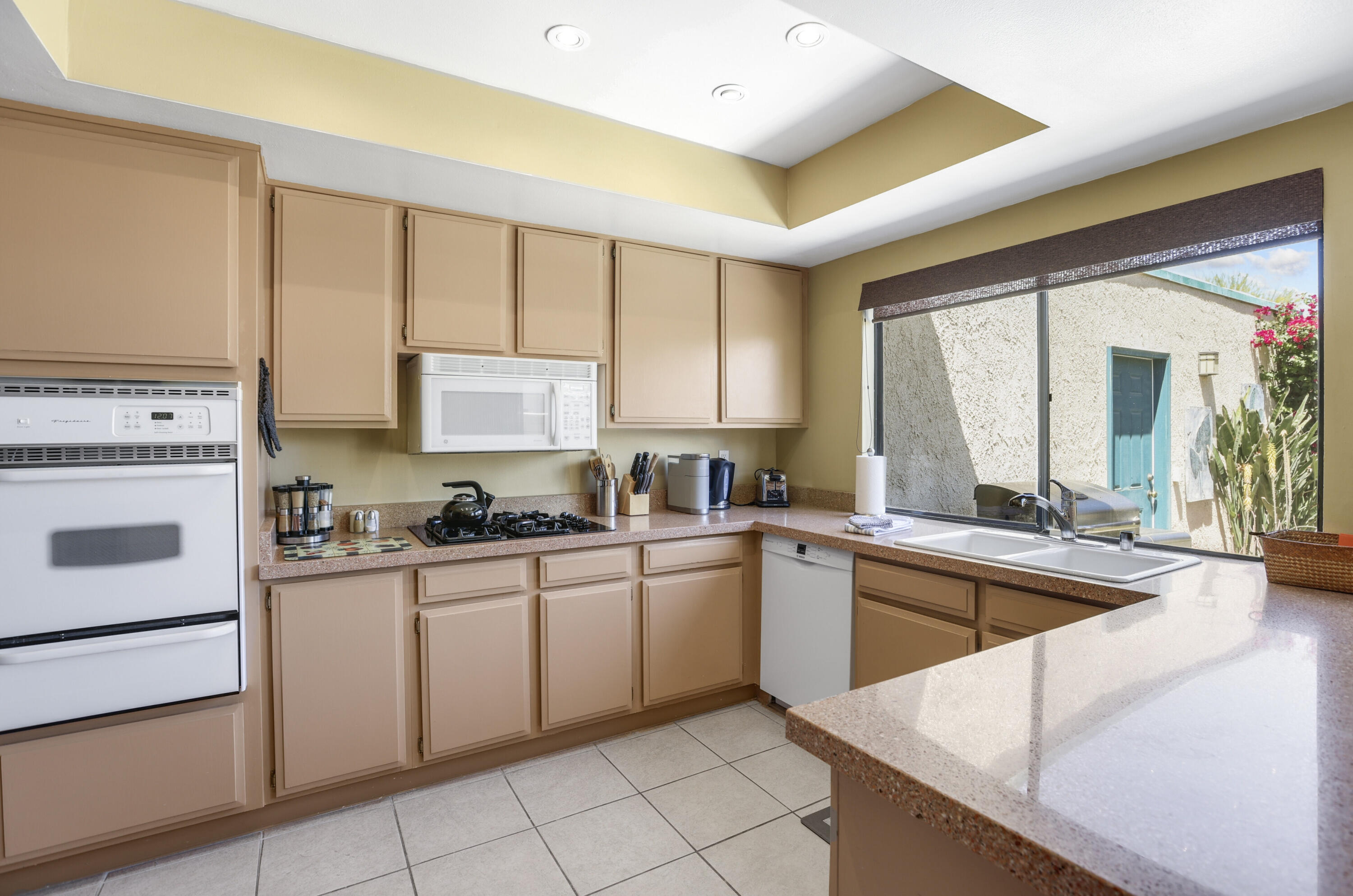 377 West Dominguez Road Palm Springs, CA 92262 - Photo 14 of 29 a kitchen with a stove a sink and a refrigerator