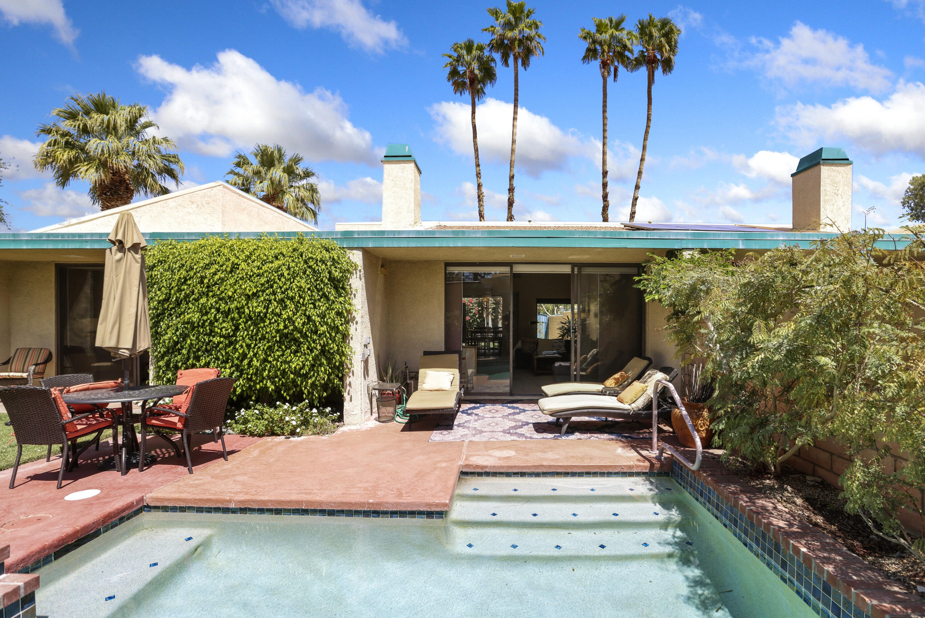 377 West Dominguez Road Palm Springs, CA 92262 - Photo 25 of 29 a view of a patio with table and chairs potted plants