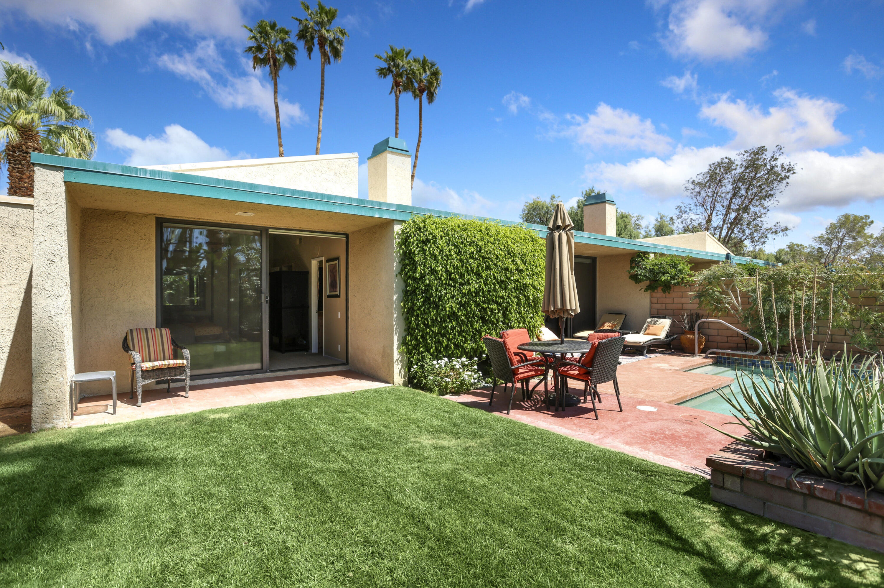 377 West Dominguez Road Palm Springs, CA 92262 - Photo 26 of 29 a view of a patio with table and chairs and potted plants