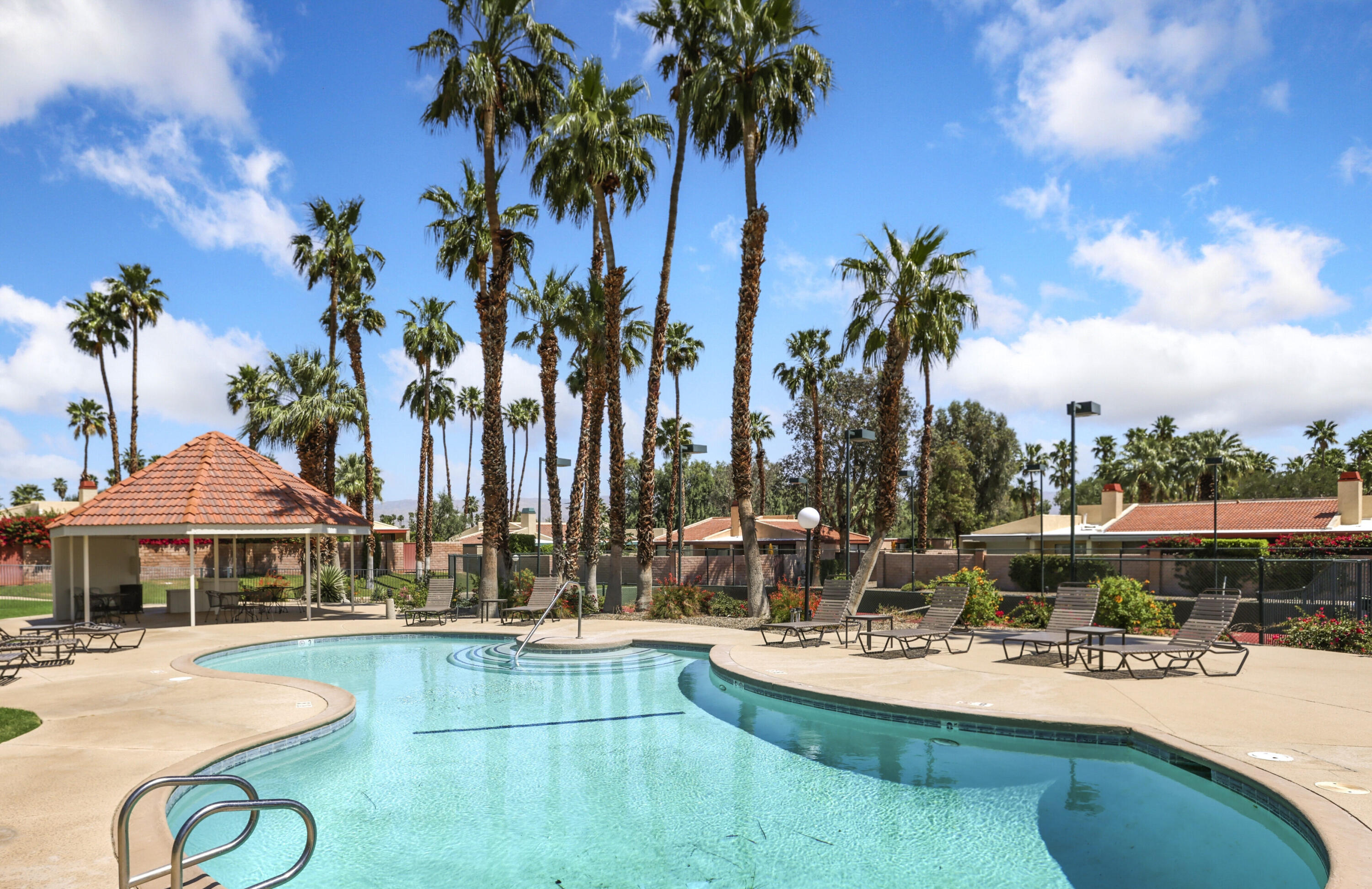 377 West Dominguez Road Palm Springs, CA 92262 - Photo 29 of 29 a view of a swimming pool with lawn chairs under an umbrella