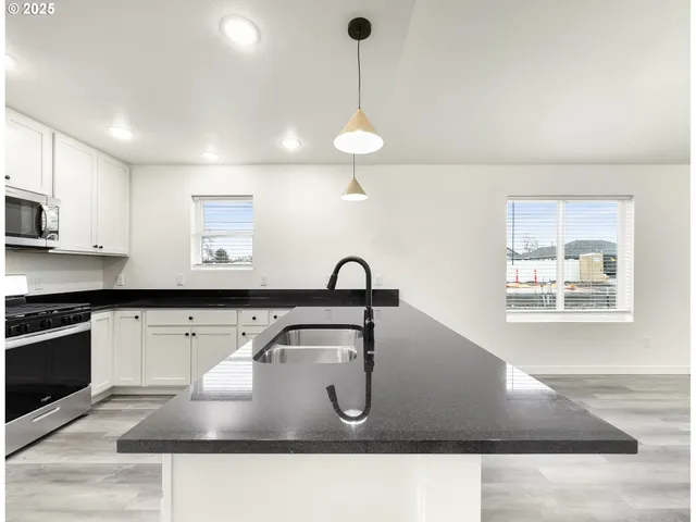 a kitchen with kitchen island a sink appliances and a counter top space