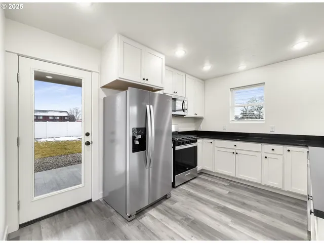 a kitchen with granite countertop a refrigerator and a sink