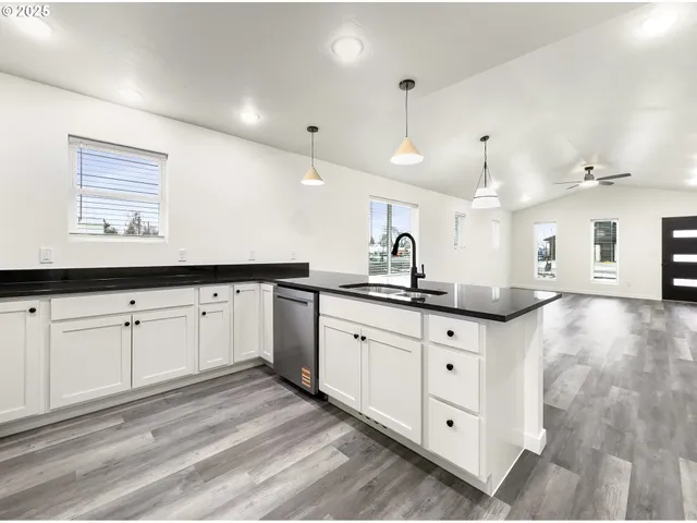 a kitchen with granite countertop a sink and cabinets