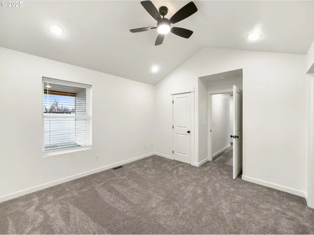 en empty room with ceiling fan and window