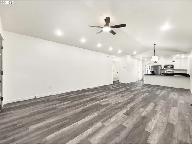 an empty room with a ceiling fan and window