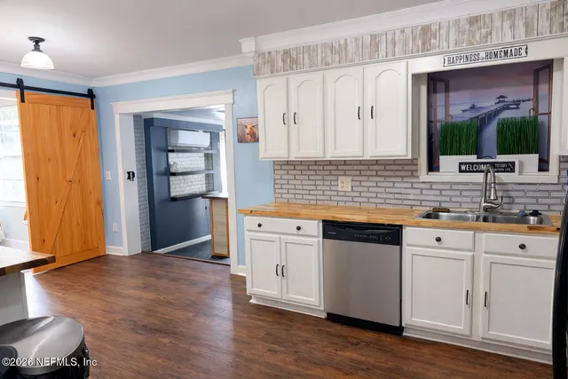 a kitchen with stainless steel appliances granite countertop a sink cabinets and wooden floor