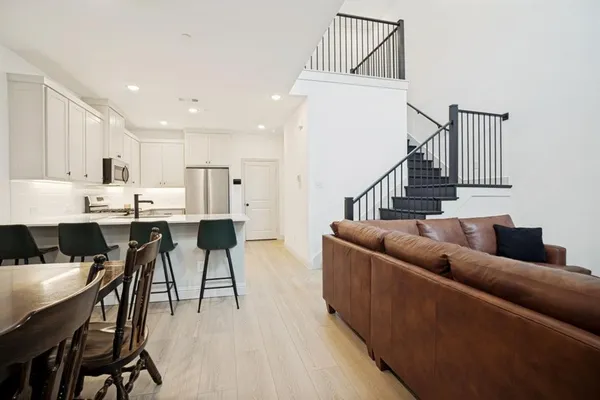 a living room with dining room and wooden floor