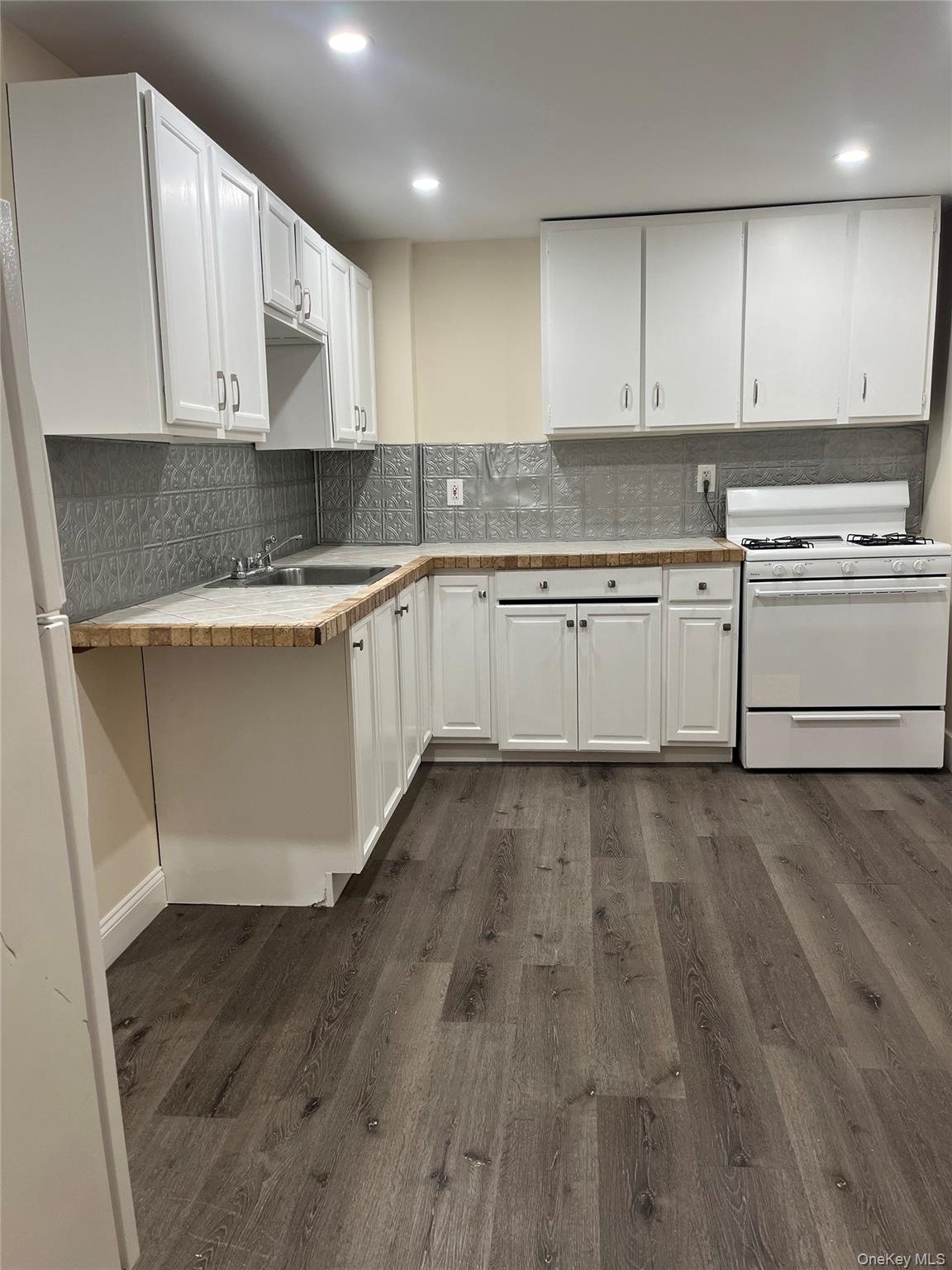 26 Franklindale Avenue, Unit 2 Wappingers Falls, NY 12590 - Photo 5 of 7 Kitchen featuring white appliances, white cabinets, dark wood finished floors, tasteful backsplash, and recessed lighting