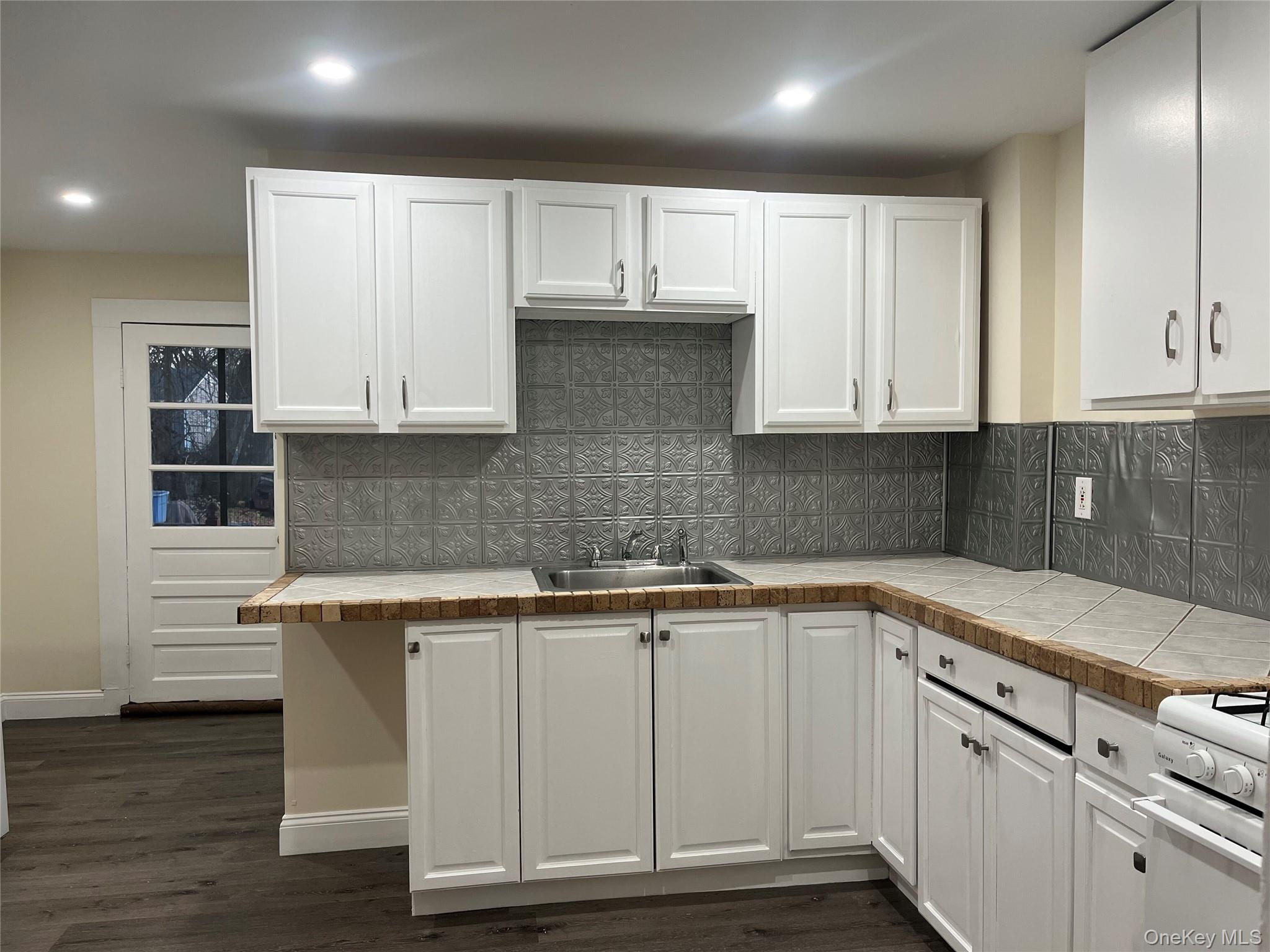 26 Franklindale Avenue, Unit 2 Wappingers Falls, NY 12590 - Photo 6 of 7 Kitchen with tile counters, tasteful backsplash, white range oven, and white cabinetry